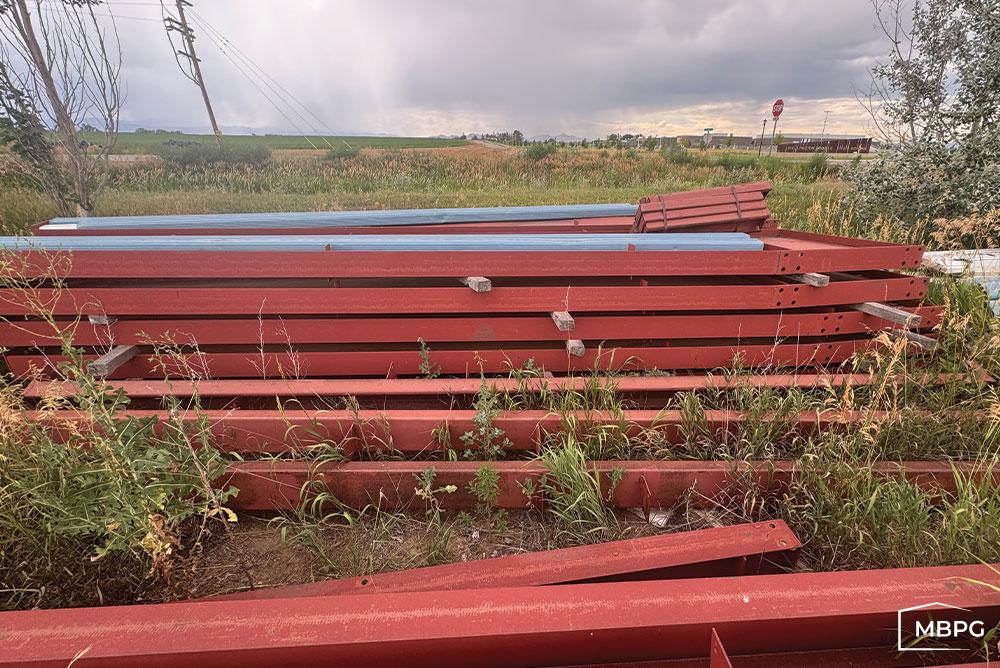 CO1826-1 Red Iron Metal Building Materials in a Field